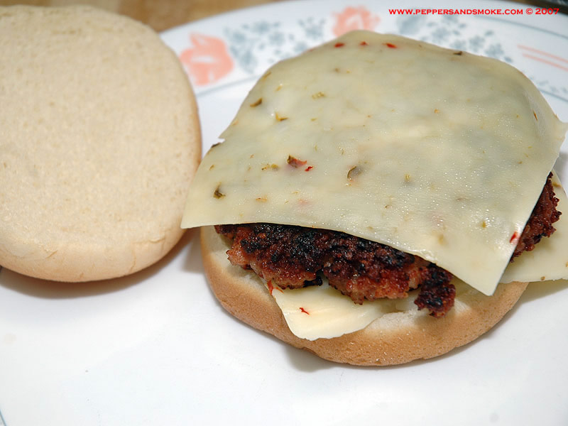 Bacon burger patty between two slices of pepper jack cheese
