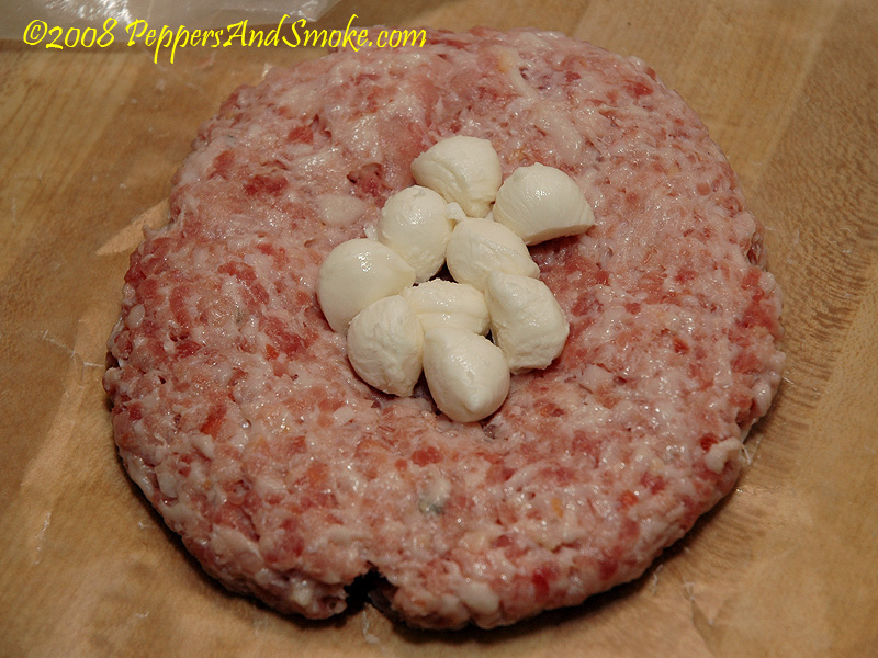 Mozzarella filling a hollow in the bacon patty