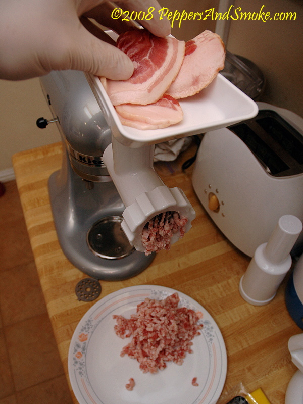 Grinding bacon in a meat grinder