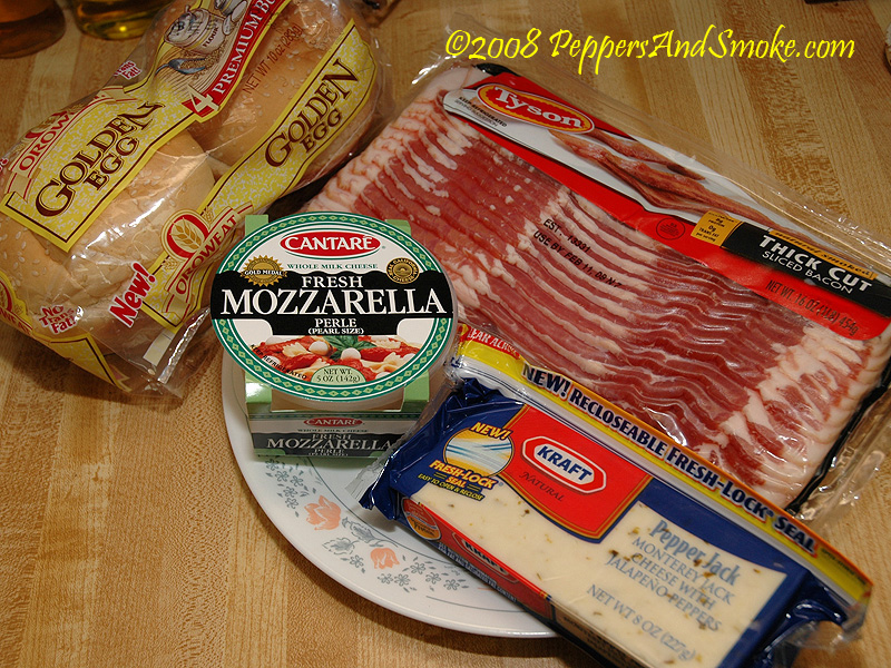 Bacon, mozzarella, pepper jack cheese and buns laid out before cooking